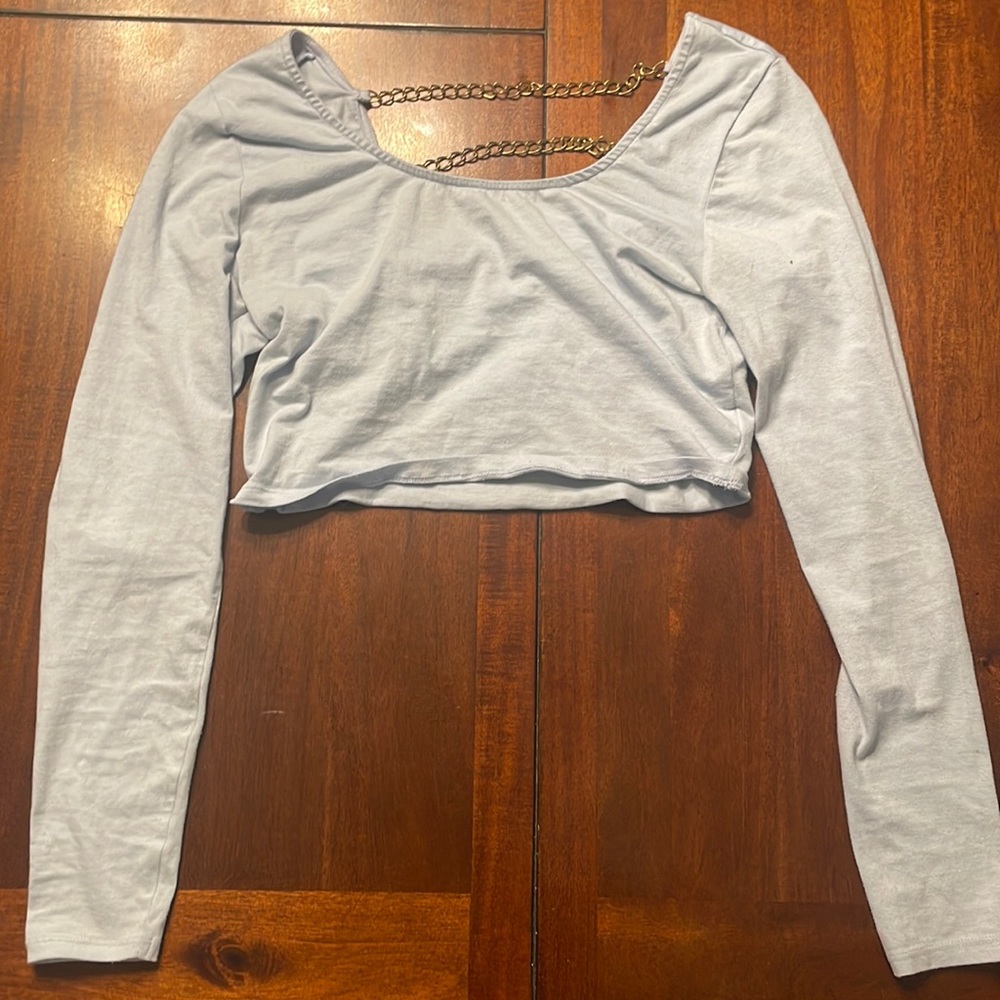 Light blue crop top with low cut back and gold chains.